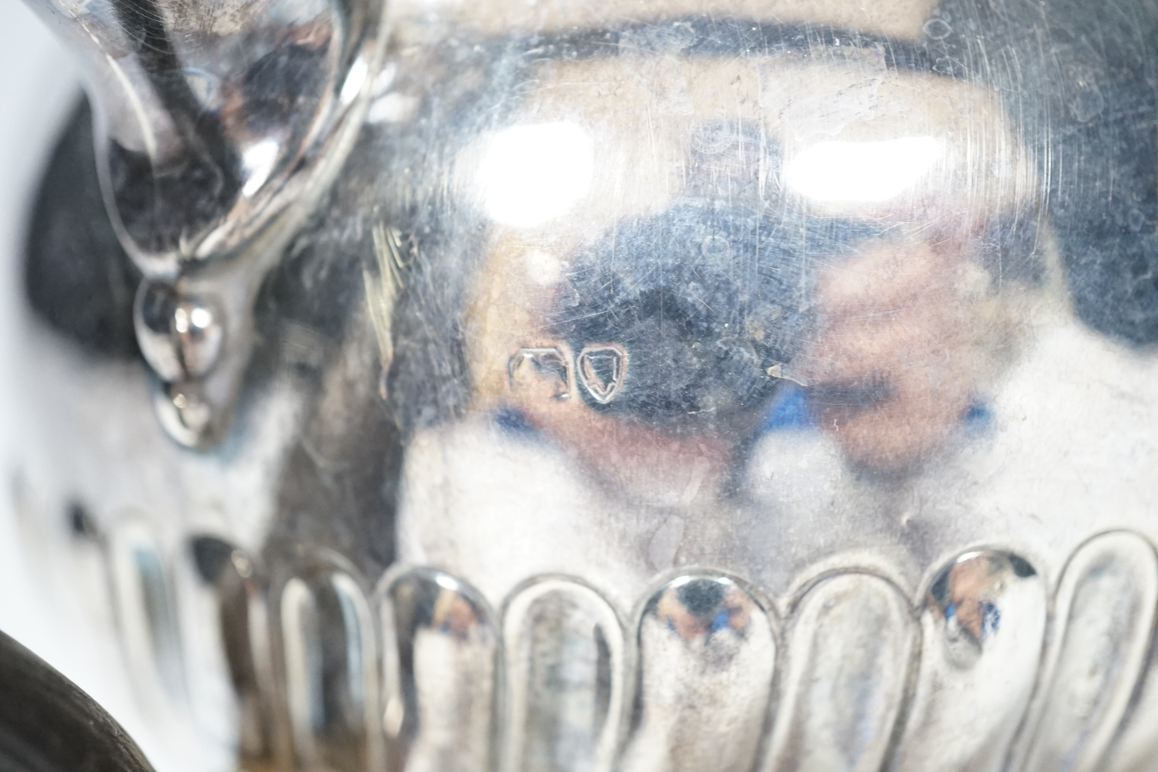 A Victorian silver bullet shaped teapot, with ebonised handle and gadrooned body, marks rubbed, London 1895, gross 321 grams
